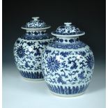A pair of 19th century Chinese blue and white jars and covers, each painted with lotus scrolling
