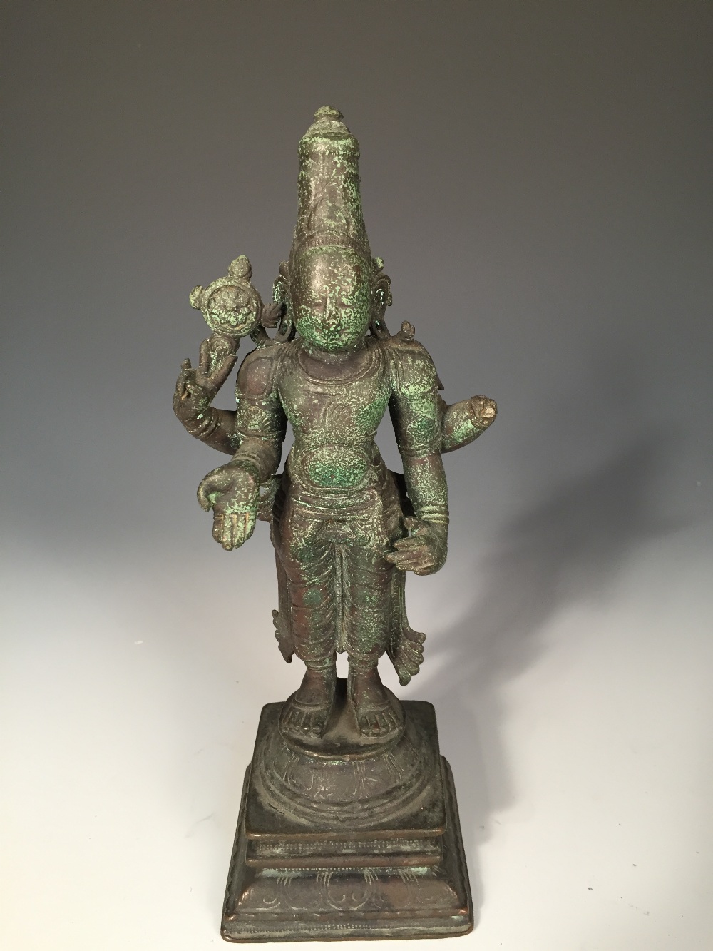 An Indian bronze figure, possibly Vishnu, the four-armed deity standing, his lower hands in