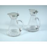 An Edwardian pair of silver mounted glass whisky noggins, the plain conical glass bodies each with