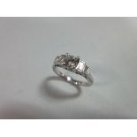 A diamond five stone and platinum ring, the central round brilliant cut diamond four claw set