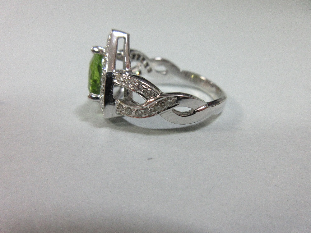 A contemporary peridot and diamond ring, the triangular cut peridot in a border of round brilliant - Image 4 of 7