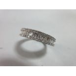 A diamond and white gold half band ring, with a channel set line of baguette cut diamonds between