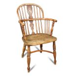 An 18th century yew wood and elm windsor chair, with saddle seat and on crinoline stretchered legs