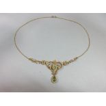 An Edwardian peridot and pearl necklace, the central art nouveau style motif set with a round cut