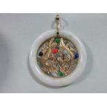 A Chinese jade and gem set pendant, composed of a ring of green flecked white jade, mounted with