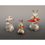 Three Lomonosov figures of rabbits, two with carrots, the larger 11.5cm high, the third with a