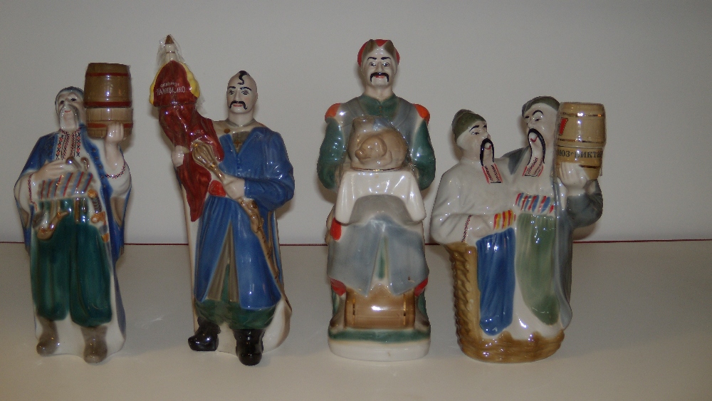 Four Polonnoe Cossack figural decanters, two holding up barrel stoppers, the third with a sceptre