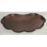 An Arts & Crafts copper tray, the scalloped kidney form with repoussé centre and engraved scroll and