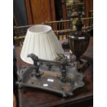 A Victorian cast iron boot scraper and a neoclassical design table lamp