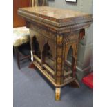 A Moorish inlaid games table, with swivel fold over top and lift out games board, 79cm x 73cm x 37