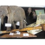 A carved wooden figure of an elephant, together with a carved parasol handle, two metal elephants,