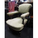 A Victorian easy armchair with ebonised frame, on casters