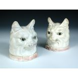 Two 20th century European pottery cat's head boxes, the white cats with green eyes, their pink