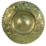 A large Newlyn school brass charger, the dished centre to a border of fish with scalloped rim