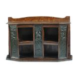 An Art Nouveau oak and bronze book shelf, the shaped top above vertical bronze panels with relief