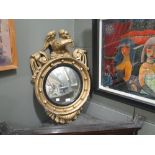 A Regency style gilt convex wall mirror with eagle surmount