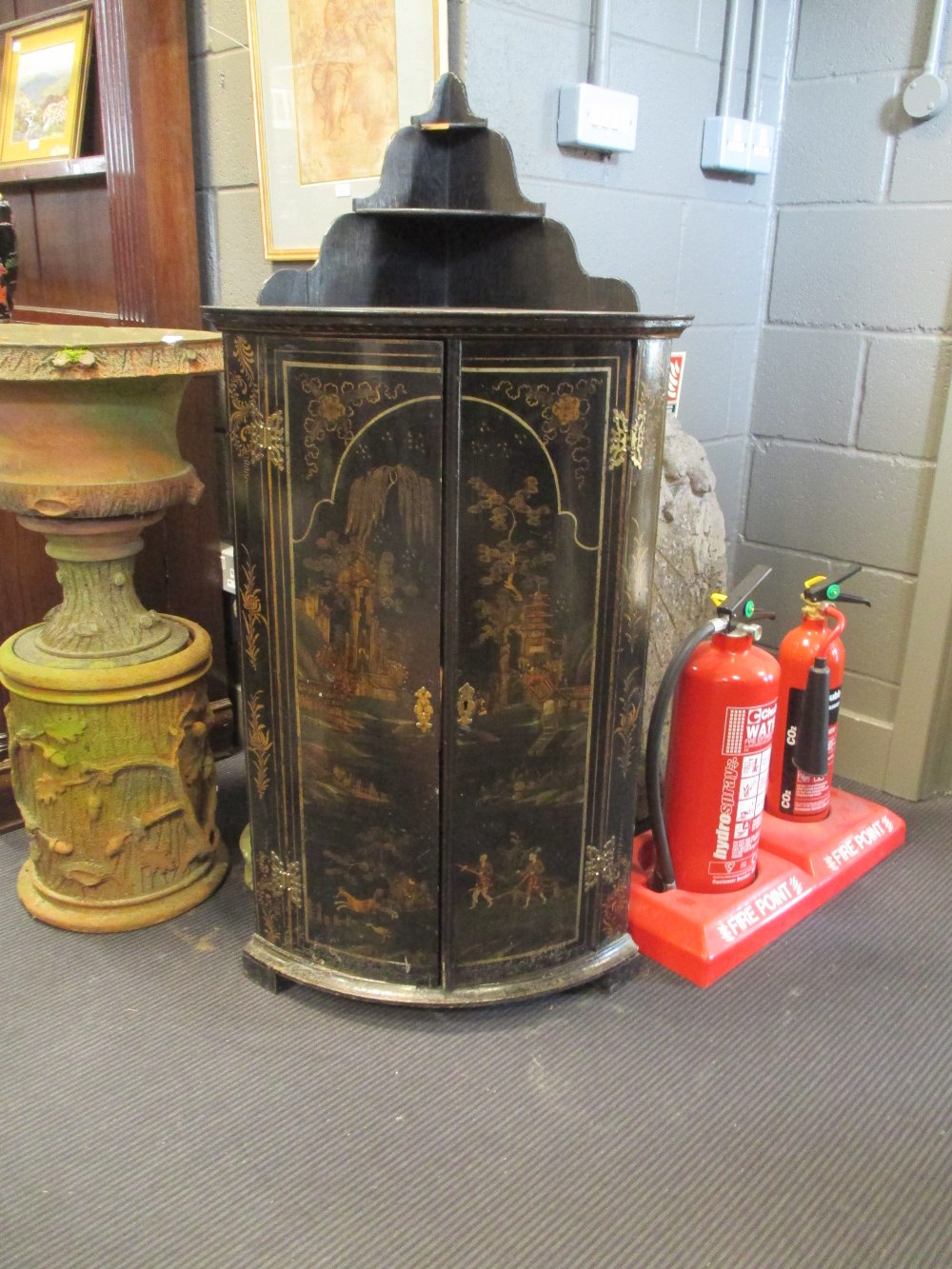 An 18th century black lacquer corner cupboard with painted decoration, 60cm wide, 125cm high