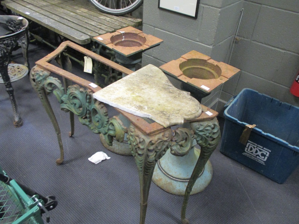 An early 20th century cast iron marble top table, a cast iron pub table and two cast iron table