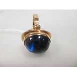 A royal blue hardstone ring (probably a synthetic sapphire), the deep oval cabochon in a collet