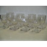 Eight glasses with facet cut glass bowls on a square foot, decanters and various other glasses