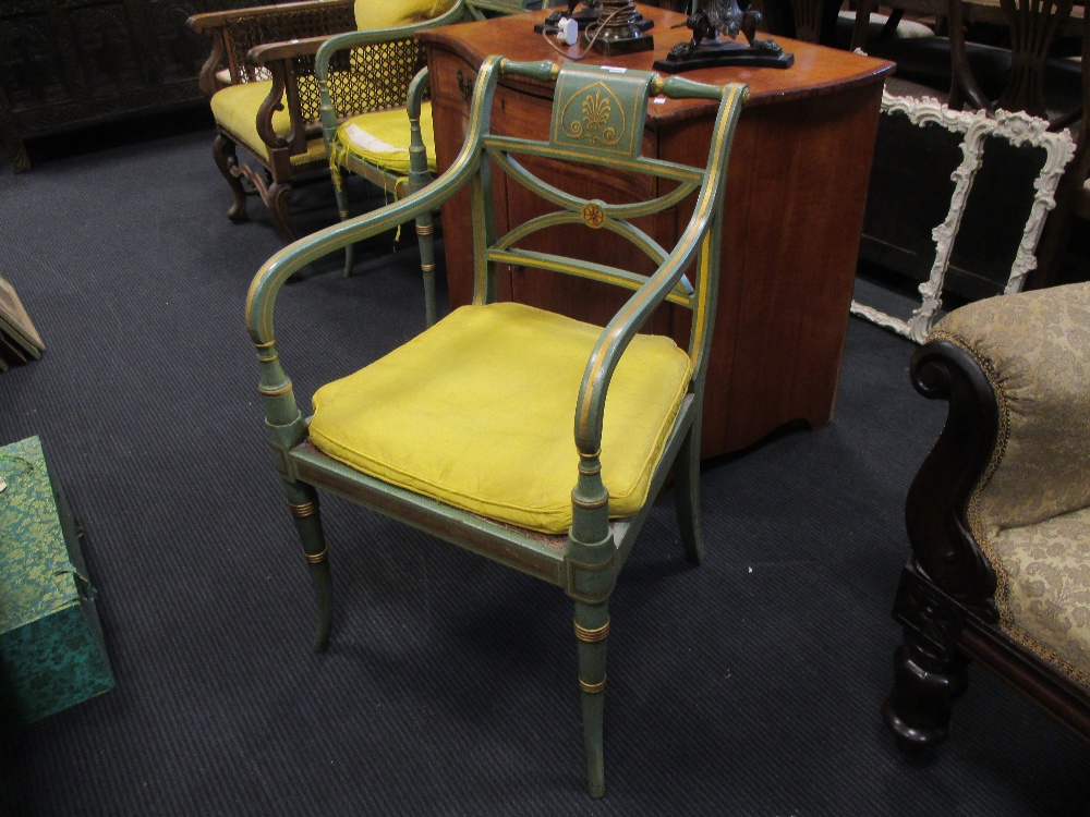 A pair of George III style green painted elbow chairs