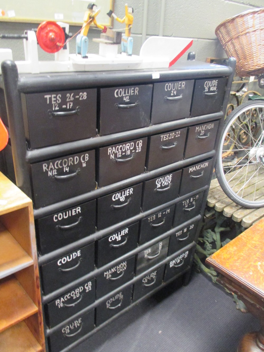 A black painted metal drawer unit, fitted with 24 named drawers, 153 x 110 x 30cm