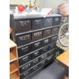 A black painted metal drawer unit, fitted with 24 named drawers, 153 x 110 x 30cm