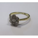 An 18ct diamond flowerhead cluster ring, the round brilliant cut stones set in to white metal to a