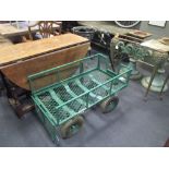 A wirework green painted trolley with handle and drop down sides