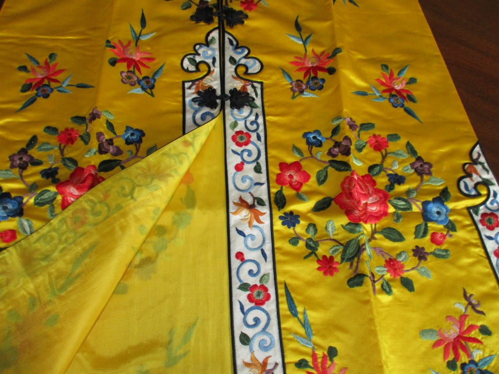A Chinese lady's silk yellow ground robe embroidered with coloured flowers, the length from collar - Image 2 of 4