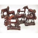 A set of eight carved wooden horses