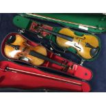 Two cased violins and bows, one of the former bearing Amati label and the other in Voigt case, the