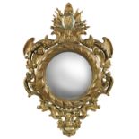 A 19th century continental gilt gesso framed convex mirror, decorated with military campaign trophy,