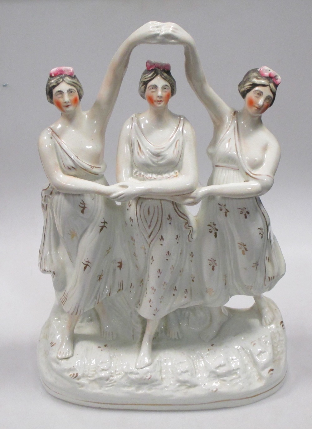 A 19th century Staffordshire group of three dancing ladies, 39cm high Hairline to the base but not