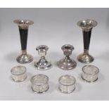 Four silver napkin rings, a pair of silver dwarf candlesticks and a pair of silver mounted horn