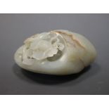 A Chinese jade pebble pierced and carved on one side with a bird and flower