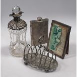 A silver mounted decanter, a frame, an electroplate hip flask and toast rack