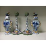 A pair of polychrome Delft candlesticks and a pair of covered vases, probably 19th century, the tree