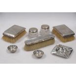 Two silver backed hairbrushes, a clothes brush, a silver ashtray, two silver topped jars and a