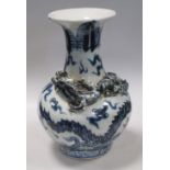 A Ming style blue and white vase applied with a dragon on its shoulders chasing a flambe red