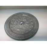 A Tang silvered bronze mirror in a brocaded box,