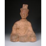 A Han dynasty red pottery figure of a seated dignitary