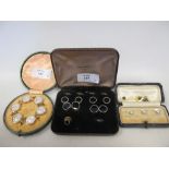 A cased set of six white enamel and gilt metal buttons in tooled green leather case, together with