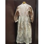 A lady's Victorian day dress, c.1860, in cream silk tafetta, with black embroidery and with a pale