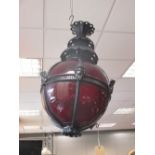 A large red glass globe and black painted hanging lantern