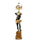 A 20th century Continental carved wood Blackamoor torchere, the standing subject bearing a seven