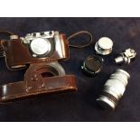 A leather cased 1938 Leica III A camera with three lenses, the camera body numbered 298802, an Elmar