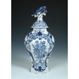 A late 18th century blue and white Delft vase and cover, one of the broader baluster sides painted