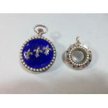 A lady's decorative fob watch and an enamel and seed pearl pendant locket, the watch with white dial