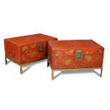 A pair of Chinese red painted vellum trunks on brass stands, decorated with floral blossom and brass